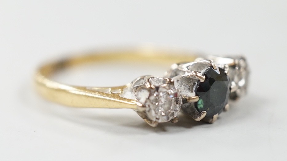 A modern 18ct gold, single stone sapphire and two stone illusion set diamond ring, size N, gross weight 3.4 grams.